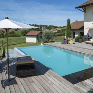 Piscine à débordement sur deux côtés, plage et margelles en bois