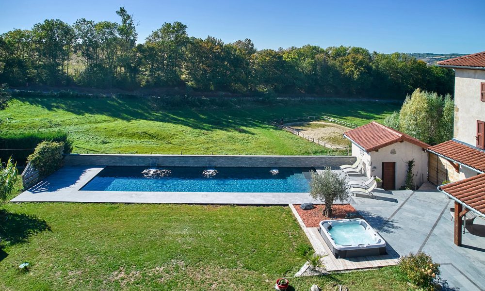 Couloir de Nage avec spa semi-encastré, margelles et plage en bois exotique