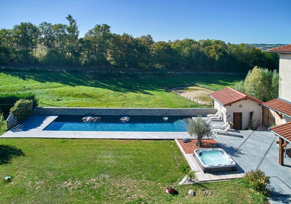 Couloir de Nage avec spa semi-encastré, margelles et plage en bois exotique